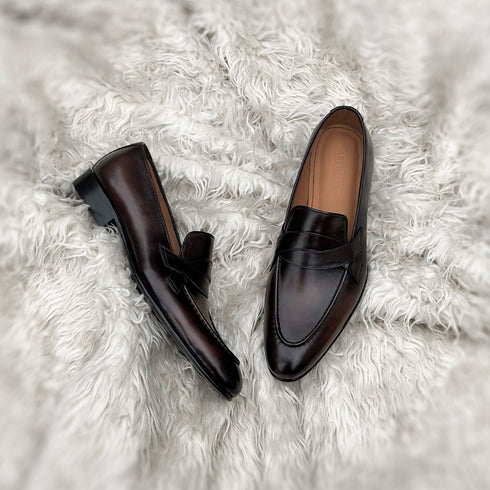 Andrew - Single component penny loafer with an elegant twisted leather tie on the facing. Hand made from the finest Calf leather with hand-stitch detailing. Soft inner naturally tanned cow leather lining. Rounded edge vegetable tanned leather sole. Finished in the very beautiful Hazelnut patina.