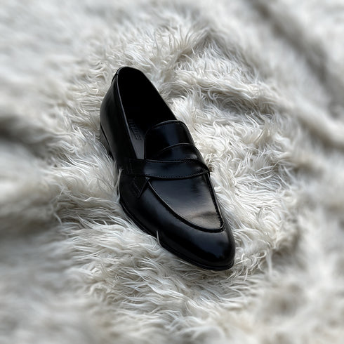 Andrew - Single component Penny loafer, made from the finest black calf leather with hand stitch detailing. The facing is adorned with a beautiful twisted leather tie, offering effortless elegance & panache