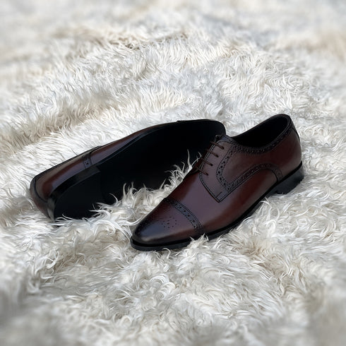 Edwin - A meticulously crafted Cap toe derby with an elegant toe medallion. The whole upper is embellished with carefully placed perforations and brogue-ing. 