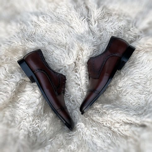 Edwin - A meticulously crafted Cap toe derby with an elegant toe medallion. The whole upper is embellished with carefully placed perforations and brogue-ing. 